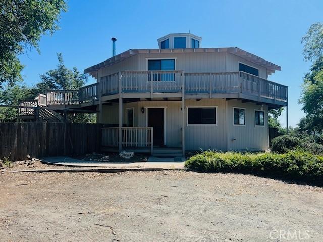 back of house featuring a porch and a balcony