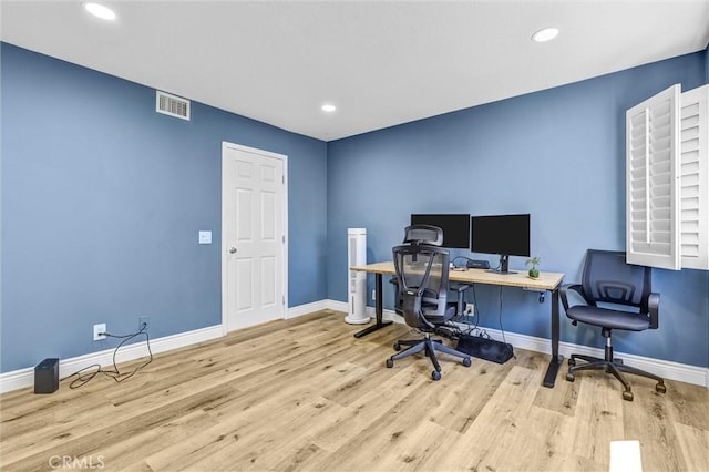 office with baseboards, visible vents, and wood finished floors