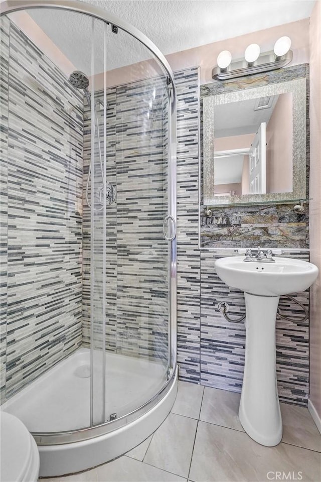 28215 Via Luis, Laguna Niguel, CA 92677 - full bath with tile patterned floors, a stall shower, a textured ceiling, toilet, and tile walls