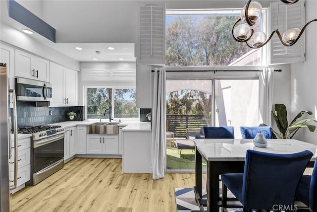 28215 Via Luis, Laguna Niguel, CA 92677 - kitchen with appliances with stainless steel finishes, a sink, light wood-type flooring, white cabinets, and recessed lighting