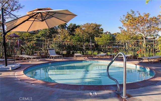 community pool featuring fence and a patio area