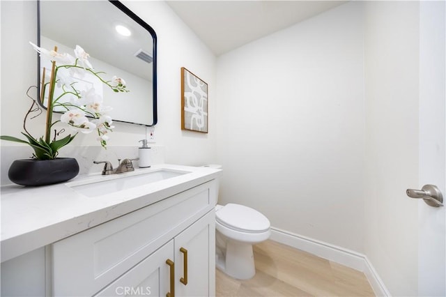 737 Lewis St, Pomona, CA 91768 - half bathroom featuring toilet, baseboards, visible vents, vanity, and wood finished floors