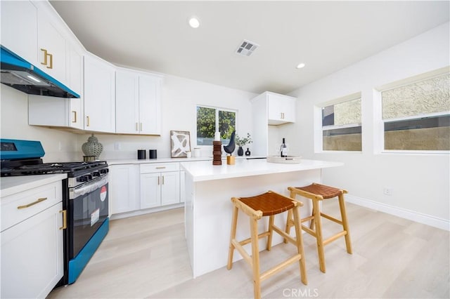 737 Lewis St, Pomona, CA 91768 - kitchen featuring stainless steel gas range, under cabinet range hood, visible vents, and light wood-style floors