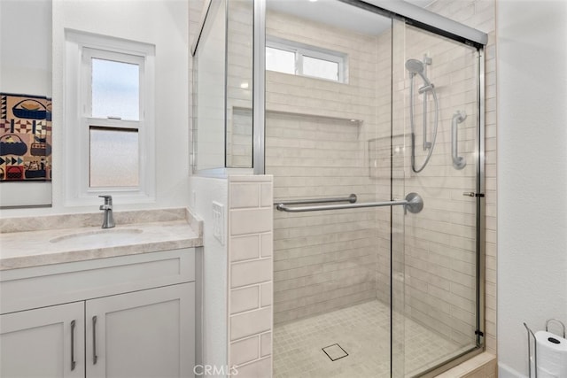 bathroom with a shower stall and vanity