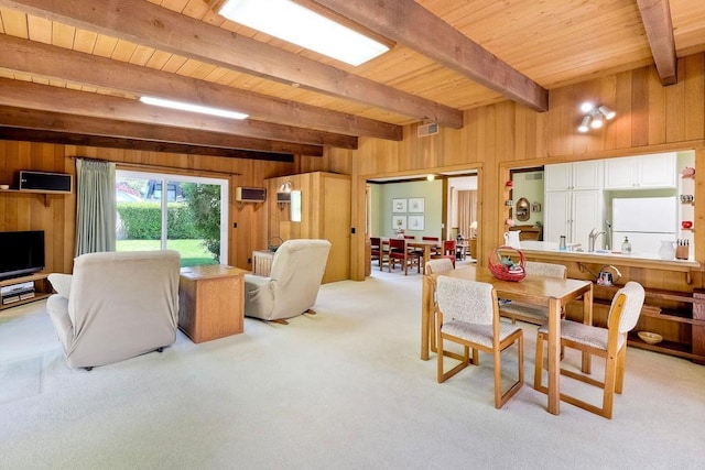 interior space featuring beam ceiling, wooden walls, wood ceiling, and light carpet
