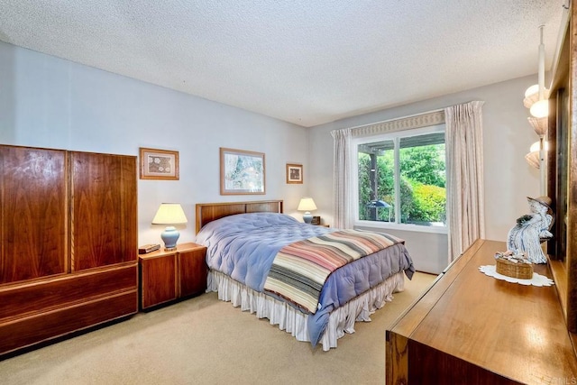 bedroom featuring light carpet and a textured ceiling