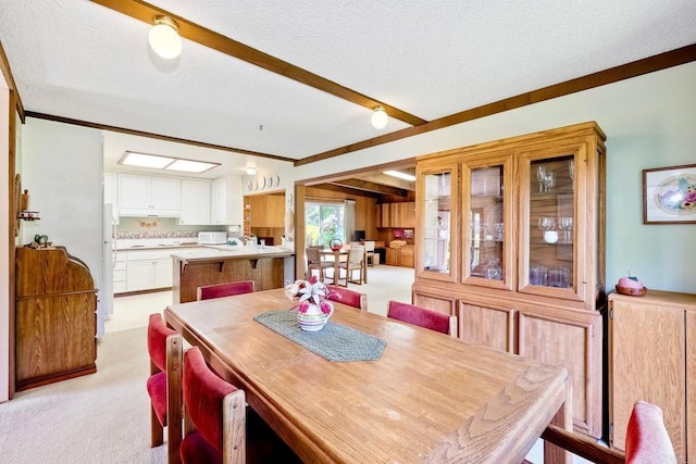 dining room with a textured ceiling, crown molding, and light colored carpet
