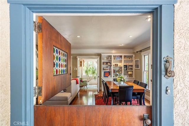 dining space featuring ornamental molding and wood finished floors