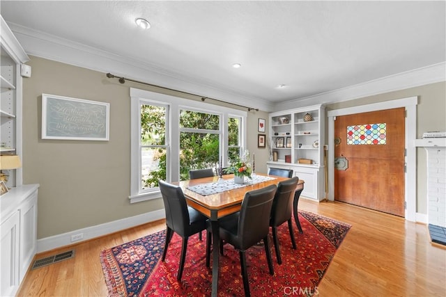 dining area featuring ornamental molding, baseboards, light wood-type flooring, and visible vents