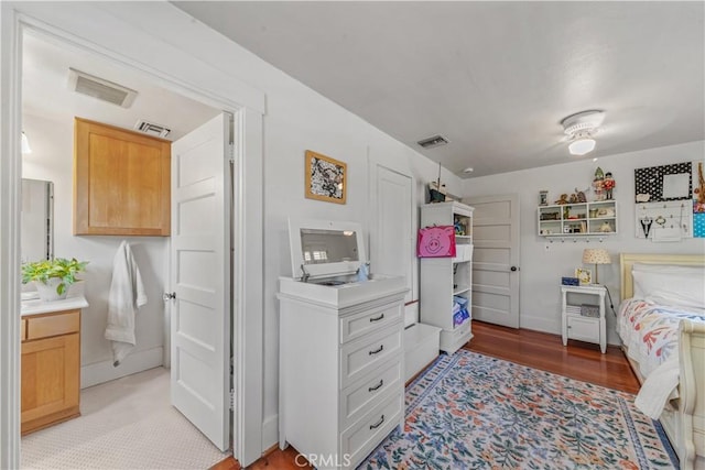bedroom featuring baseboards, light wood-type flooring, and visible vents
