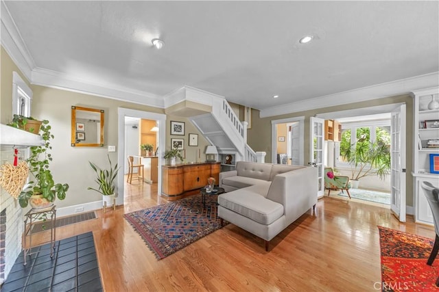 living area with crown molding and wood finished floors