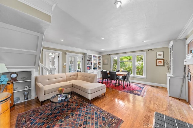 living room featuring wood finished floors, baseboards, ornamental molding, and recessed lighting