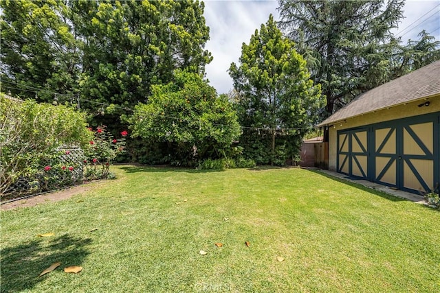 view of yard with an outbuilding, a storage shed, and fence