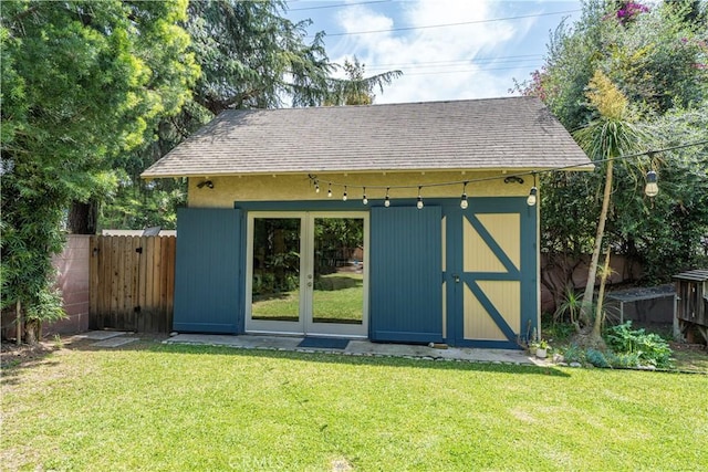view of outdoor structure with an outdoor structure, french doors, and fence