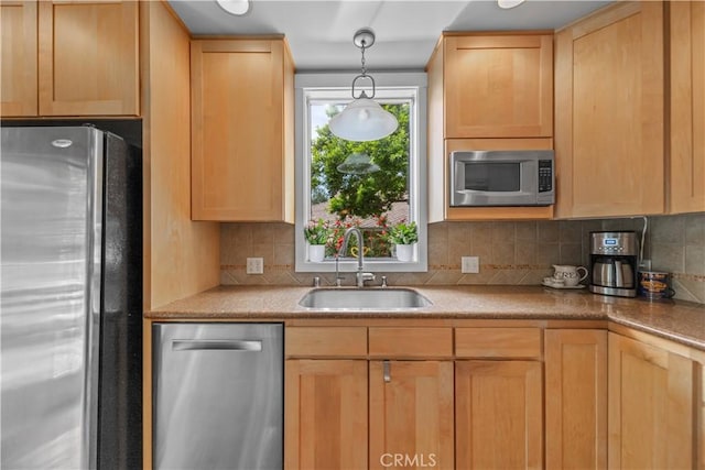 kitchen featuring a sink, decorative light fixtures, backsplash, light brown cabinets, and appliances with stainless steel finishes