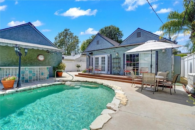 rear view of property with a patio, french doors, stucco siding, and a fenced backyard
