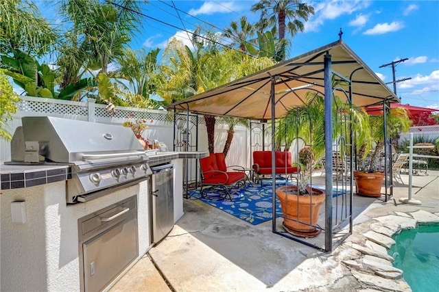 view of patio featuring area for grilling, exterior kitchen, and a fenced backyard