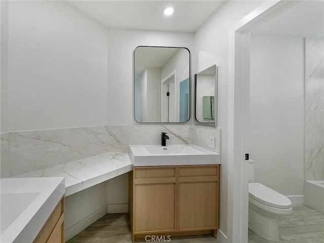 full bathroom featuring toilet, vanity, and a tub to relax in