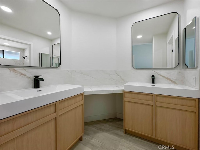 bathroom with a sink, two vanities, backsplash, and recessed lighting