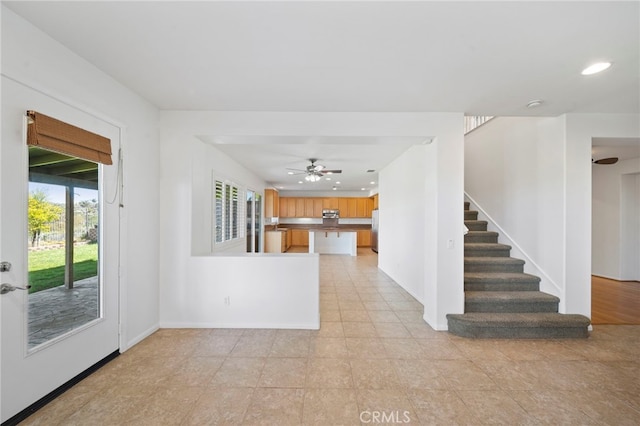 unfurnished living room with recessed lighting, baseboards, ceiling fan, light tile patterned flooring, and stairs