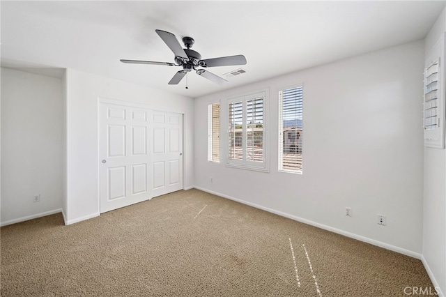unfurnished bedroom featuring carpet, visible vents, baseboards, and a closet