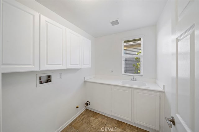 laundry area with baseboards, hookup for a washing machine, visible vents, a sink, and cabinet space