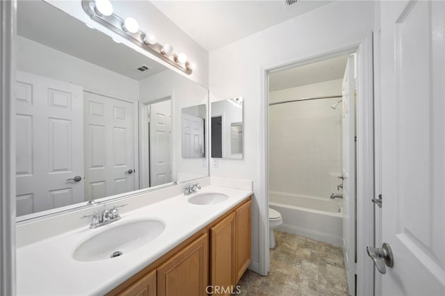 bathroom with a sink, double vanity, toilet, and visible vents