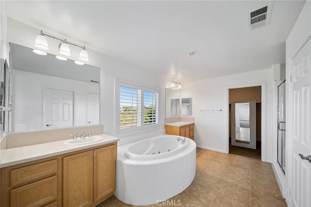 bathroom featuring a whirlpool tub, two vanities, a shower stall, and tile patterned flooring