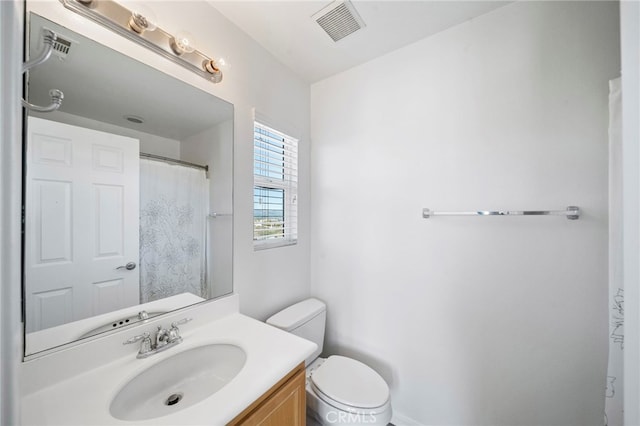 full bath featuring toilet, vanity, and visible vents
