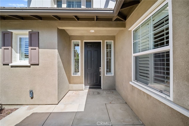 property entrance featuring a patio and stucco siding