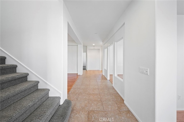 hall with stairs and baseboards