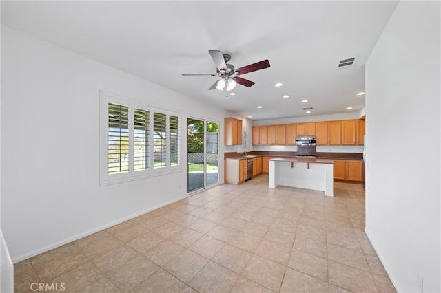 kitchen featuring stainless steel appliances, ceiling fan, baseboards, recessed lighting, and dark countertops