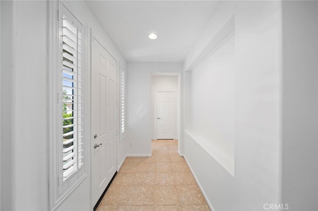 hall with baseboards and recessed lighting