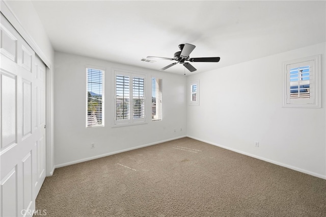unfurnished bedroom featuring a closet, carpet, baseboards, ceiling fan, and visible vents