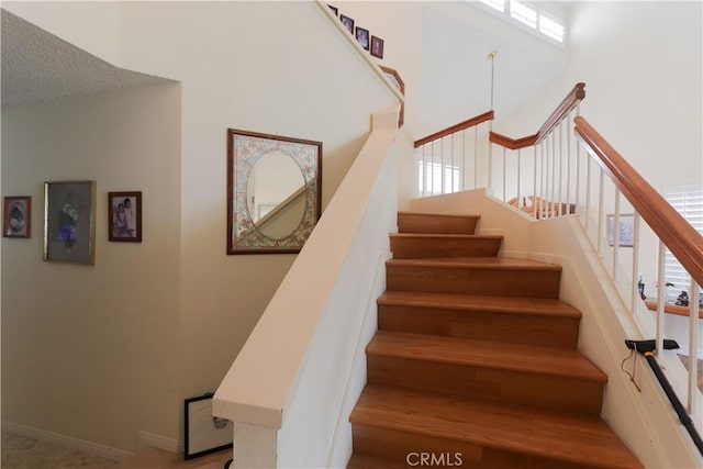 12592 Arlington Pl, Chino, CA 91710 - staircase with a towering ceiling, plenty of natural light, and baseboards
