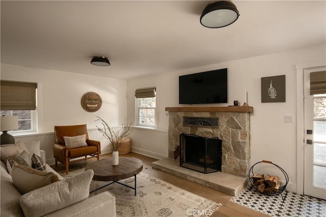 920 Oak Rd, Lake Arrowhead, CA 92385 - living room featuring baseboards, a stone fireplace, and wood finished floors