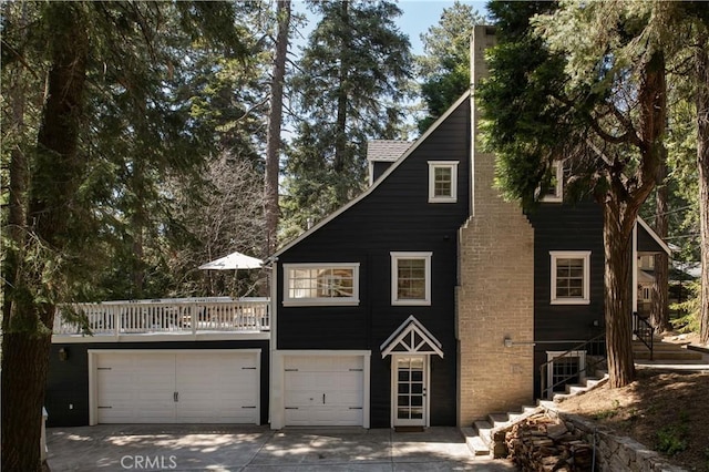920 Oak Rd, Lake Arrowhead, CA 92385 - view of front facade with concrete driveway, stairway, and an attached garage
