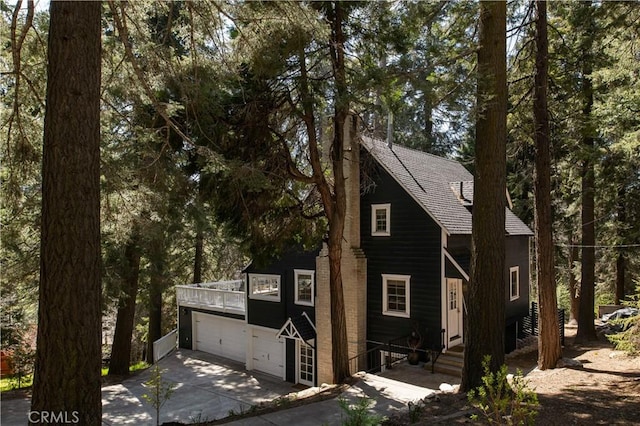 920 Oak Rd, Lake Arrowhead, CA 92385 - chalet / cabin featuring concrete driveway, roof with shingles, and a garage