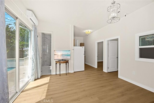 67 W Wistaria Ave, Arcadia, CA 91007 - unfurnished dining area featuring a wall unit AC, light wood-type flooring, baseboards, and a chandelier