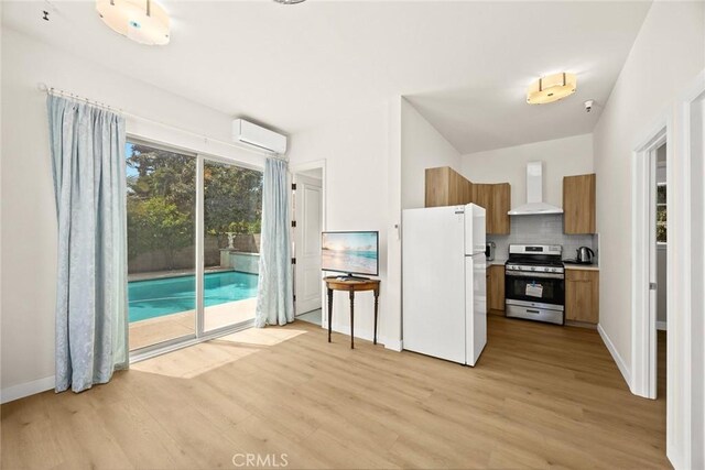 67 W Wistaria Ave, Arcadia, CA 91007 - kitchen with gas stove, freestanding refrigerator, wall chimney range hood, and light wood finished floors