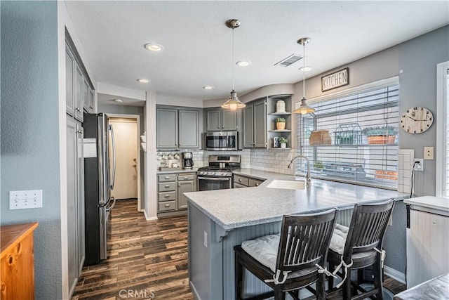 kitchen featuring gray cabinetry, visible vents, appliances with stainless steel finishes, and a sink