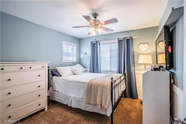 bedroom with a ceiling fan and dark carpet