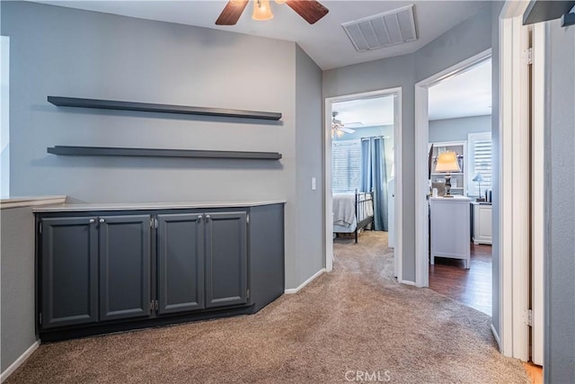 hallway featuring carpet flooring, visible vents, and baseboards