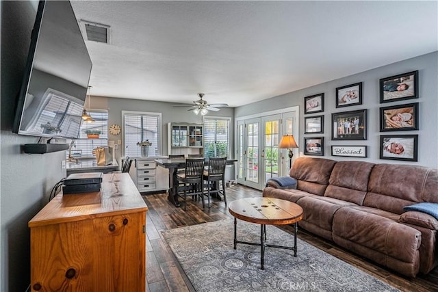 living area featuring ceiling fan, french doors, visible vents, and dark wood-type flooring
