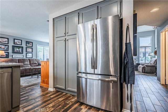 kitchen with recessed lighting, dark wood-style flooring, open floor plan, stainless steel appliances, and gray cabinets