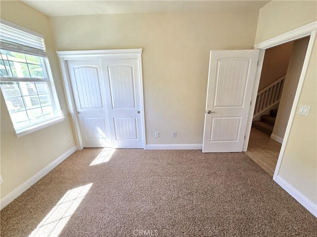 unfurnished bedroom featuring carpet flooring, a closet, and baseboards