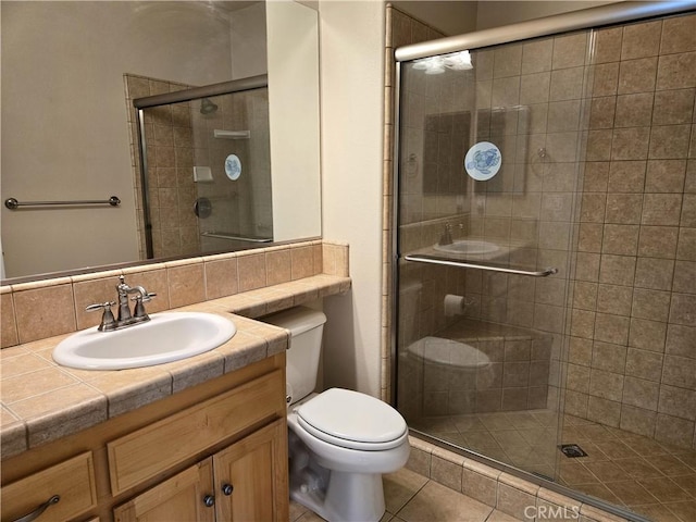 full bathroom featuring tile patterned floors, vanity, toilet, and a shower stall