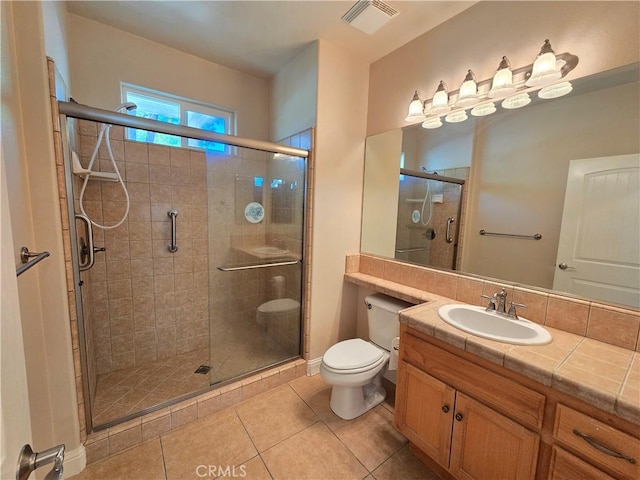 bathroom featuring toilet, vanity, visible vents, tile patterned flooring, and a shower stall