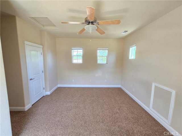 carpeted empty room featuring ceiling fan, baseboards, and visible vents