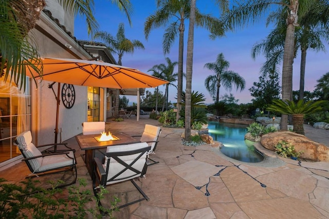 view of patio / terrace with a fire pit and an outdoor pool